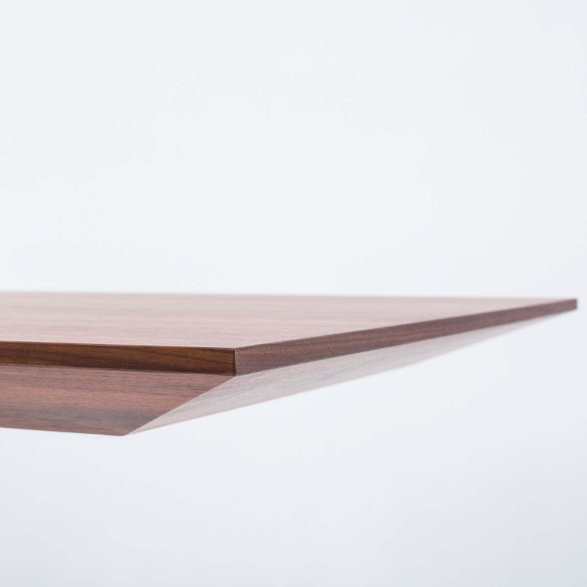 Détail du bord biseauté du plateau en placage noyer américain dun bureau de direction