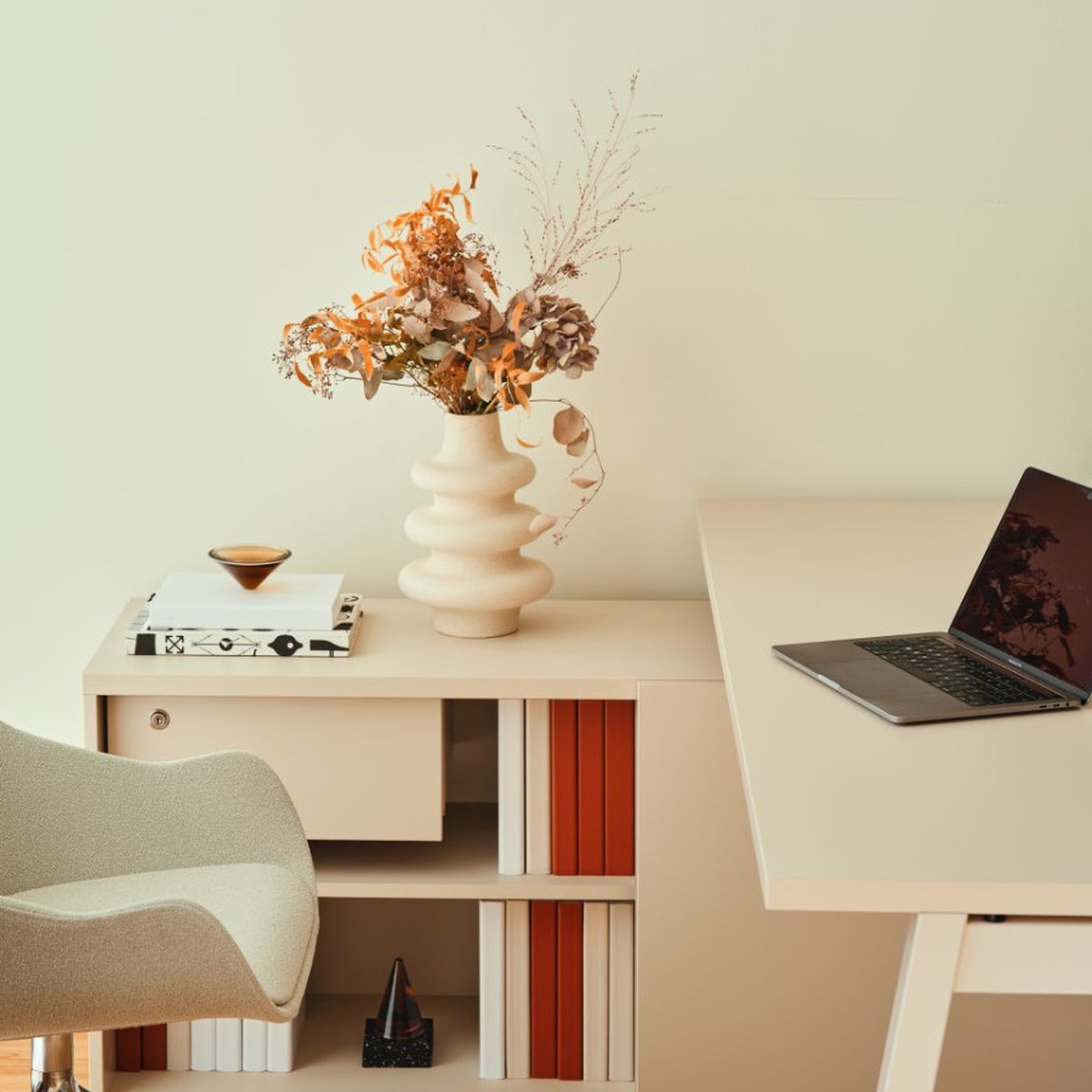 Armoire de rangement beige avec tiroir à serrure et niches, à côté du plateau du bureau