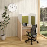 Fauteuil de bureau à dossier résille et assise vert acide devant un poste cloisonné