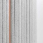 Détail des parois rembourrées en tissu gris de la cabine acoustique