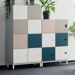 Deux casiers de bureau blancs à portes blanches, grises, rose clair et bleues dans un open space
