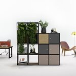 Séparateur d'espace à cases en acier noir avec plantes et caissons graphite et beige, entre bureaux et coin salon