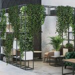 Étagère de séparation à cases garnie de plantes tombantes et de bacs blancs dans un espace lounge