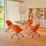 Fauteuils tapissés orange à roulettes autour d'une table ronde dans une salle de réunion lumineuse