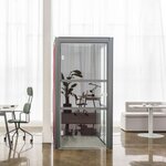 Cabine acoustique individuelle vitrée à structure anthracite dans un open space lumineux