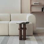 Canapé modulaire crème à base cubique devant une étagère murale