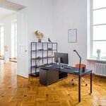 Bureau de direction noir avec armoire de retour noire dans un bureau lumineux à parquet
