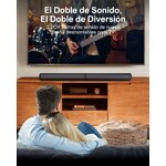 Barra de sonido completa sobre un mueble frente al televisor