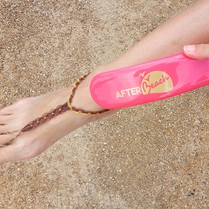 Brosse de plage rose logo or en action jambe femme