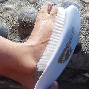 Brosse à sable blanche logo or en action pied enfant