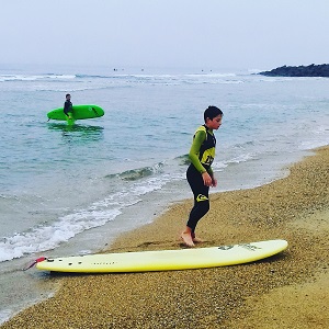 Jeune garçon prêt de sa planche après une cession de surf