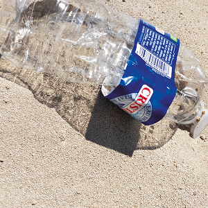 Bouteille d'eau en plastique écrasée dans le sable