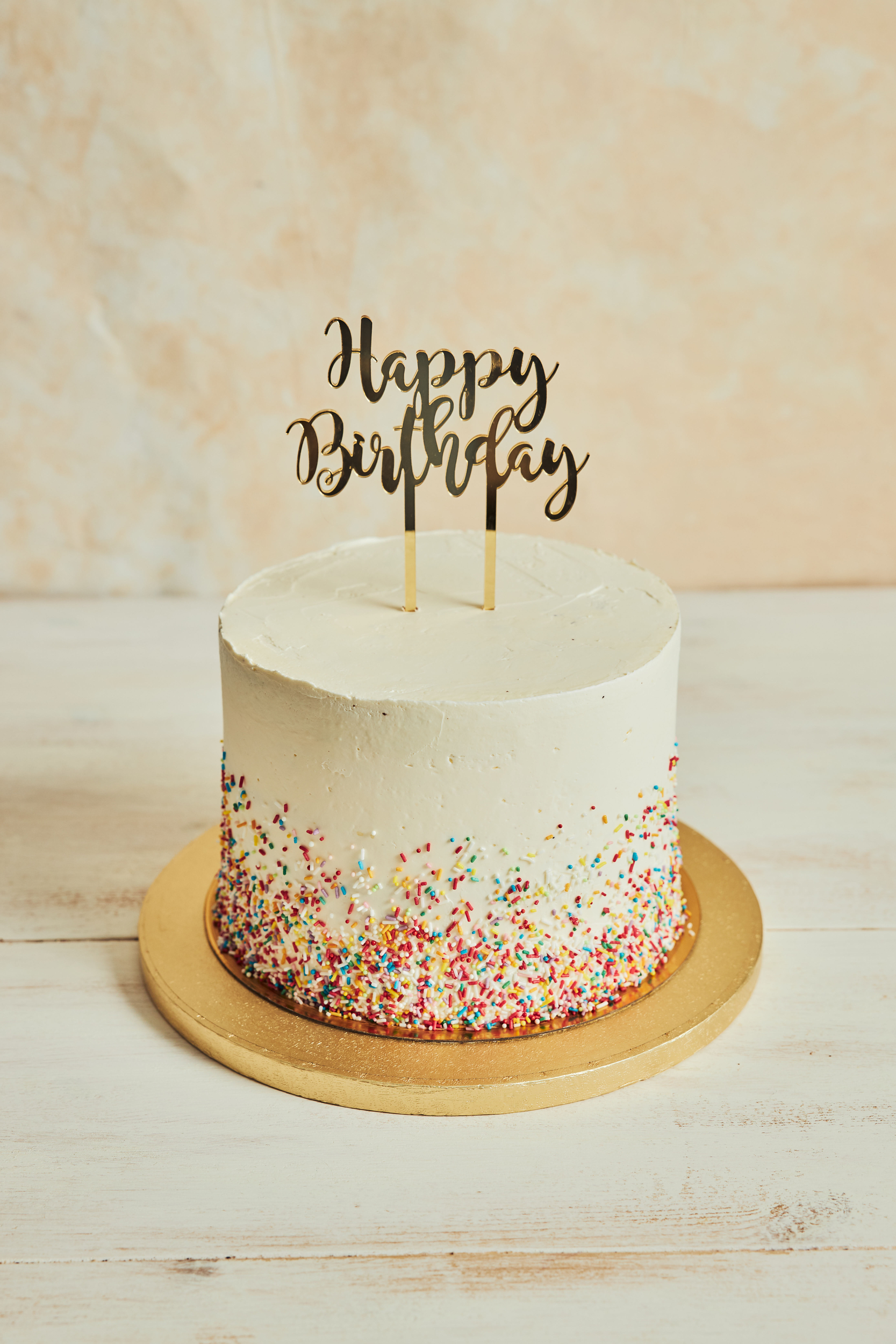cake-with-happy-birthday-cake-topper-sprinkles-wooden-board-table