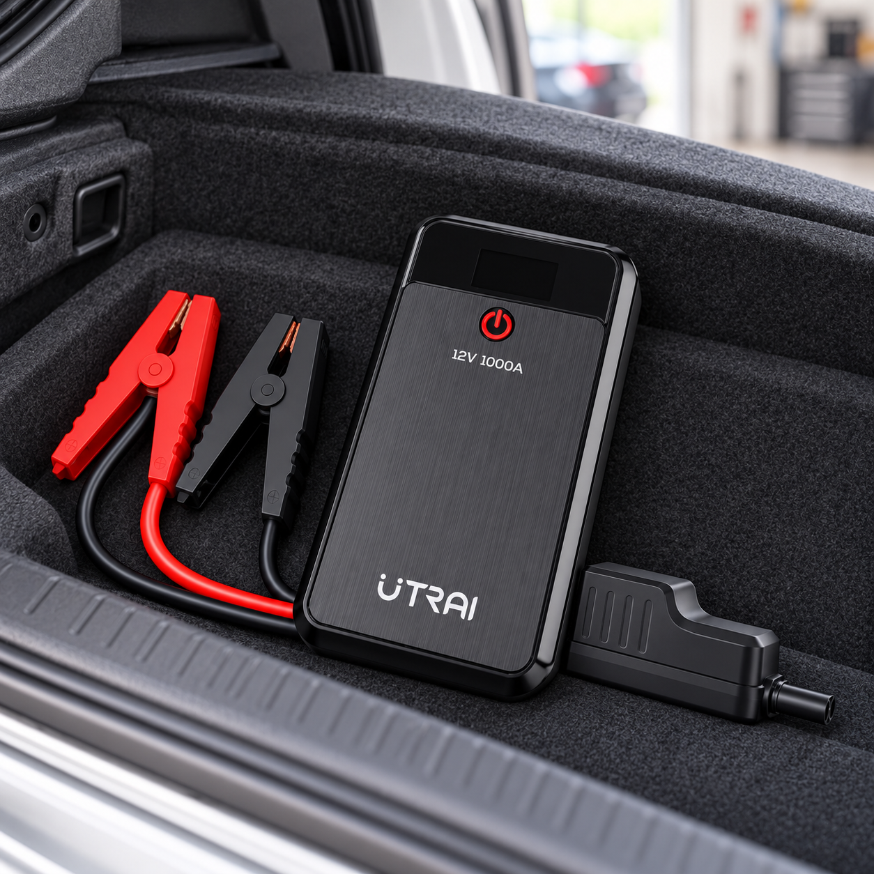 Booster 12 V et son kit rangés dans un coffre de voiture