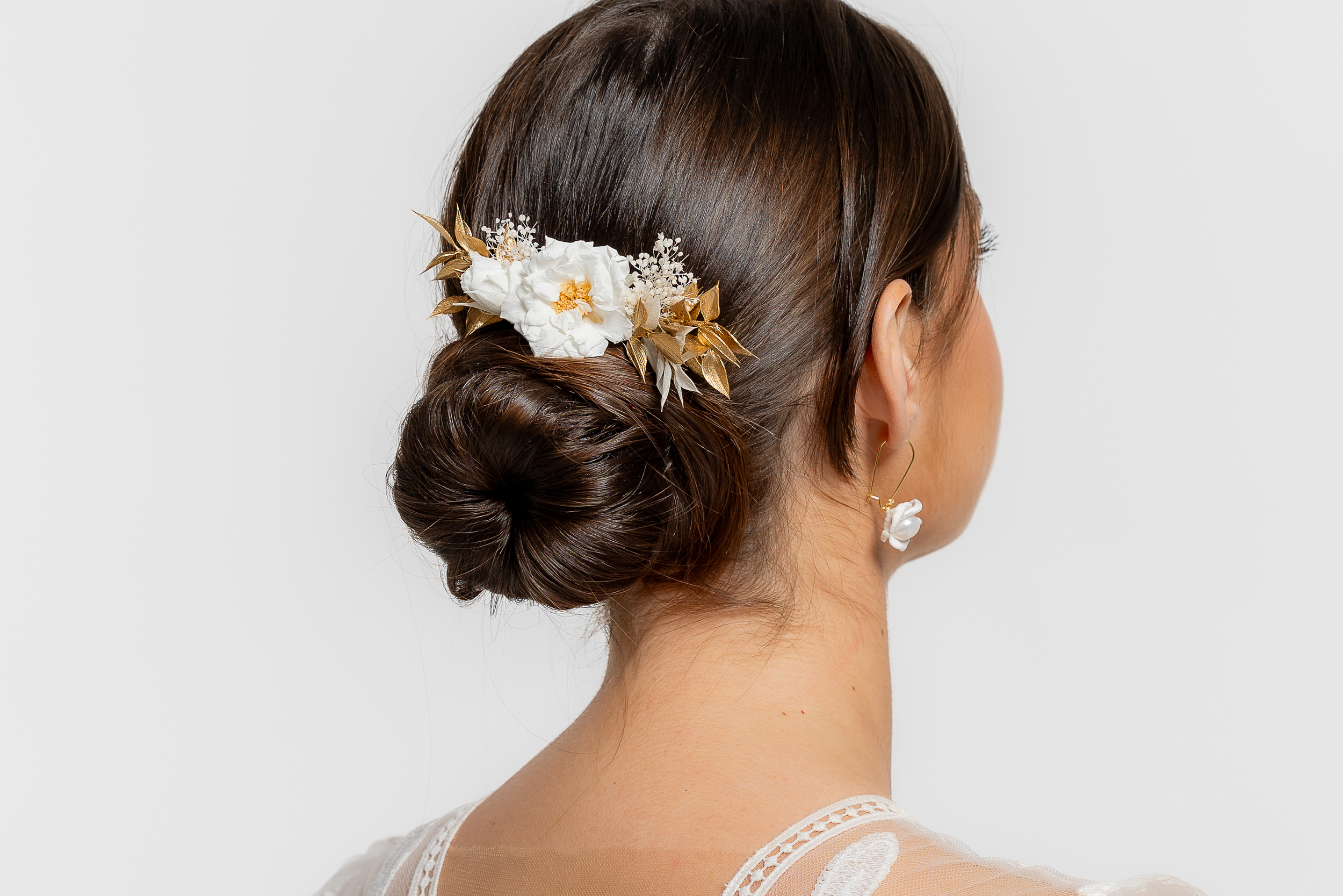 Découvrez le magnifique peigne à cheveux fleuri FELICIA de la collection Mom’Zelle Bijoux, l'accessoire incontournable pour les futures mariées, demoiselles d'honneur, communions, soirées habillées. Ce peigne fleurs stabilisées doré est orné d'une sublime rose sauvage stabilisée, d'une petitie rose blanche,de feuilles de ruscus dorées et blanches et gypsophile blanc. Son style bohème et champêtre lui confère une élégance extrême, en faisant ainsi le choix parfait pour sublimer la tenue d'une demoiselle d'honneur ou de ses convives.