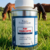 Pot de Pur’Fourchette Equi Cosmétique dans l’herbe, avec des chevaux au pré en arrière-plan