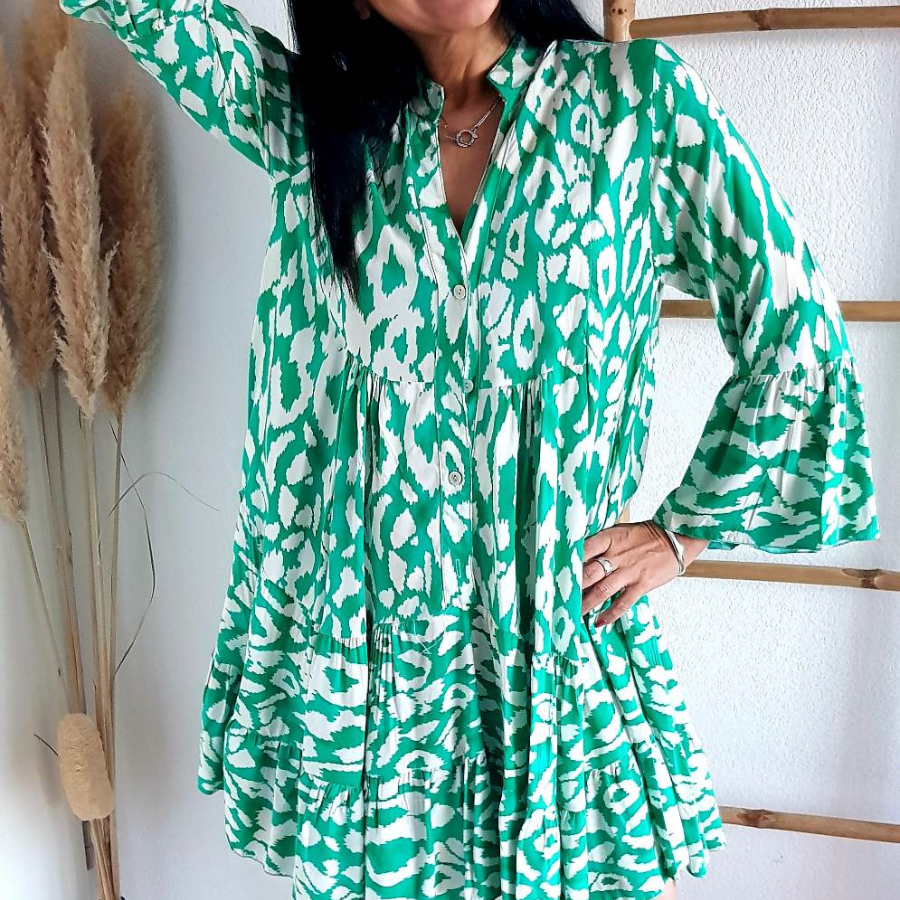 Cette robe pour femme est courte et présente un imprimé vert vibrant.