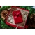 Un coffret cadeau rouge joliment emballé au milieu de pommes de pin et de verdure, parfait pour la décoration de Noël