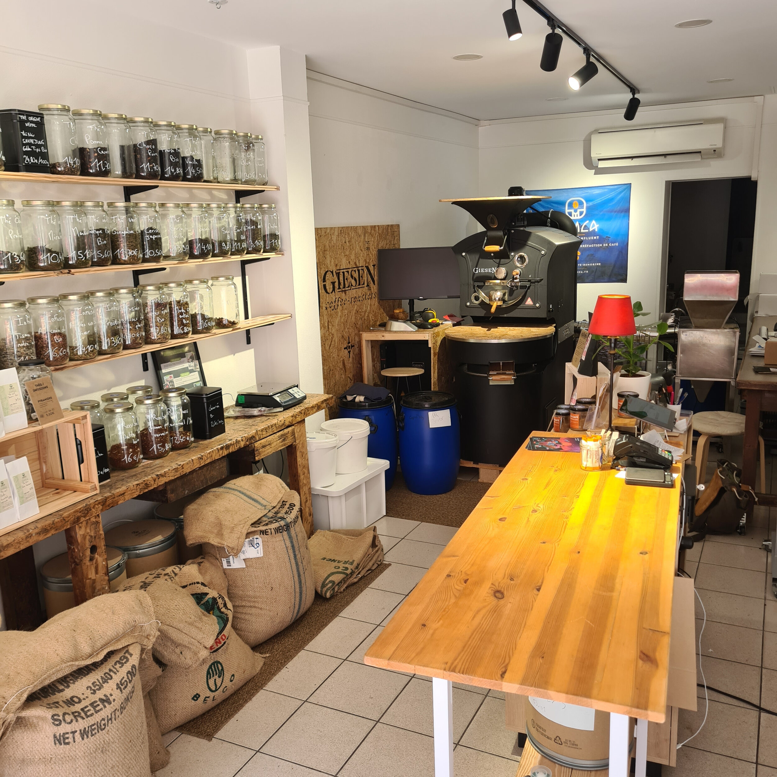 Intérieur de la boutique JUMCA avec le torréfacteur Giesen et les sacs de café vert
