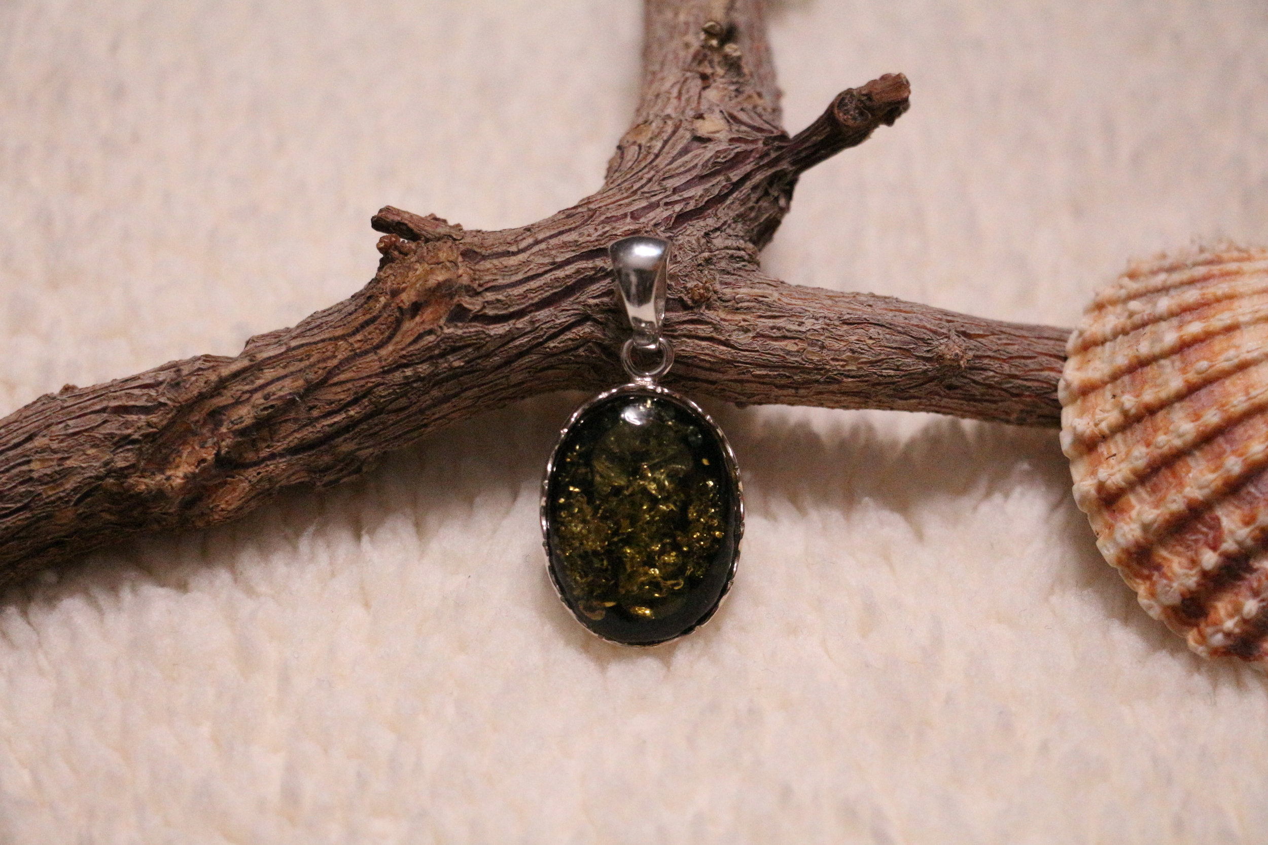 Pendentif de forme ovale en ambre vert véritable et argent 925°/°°.