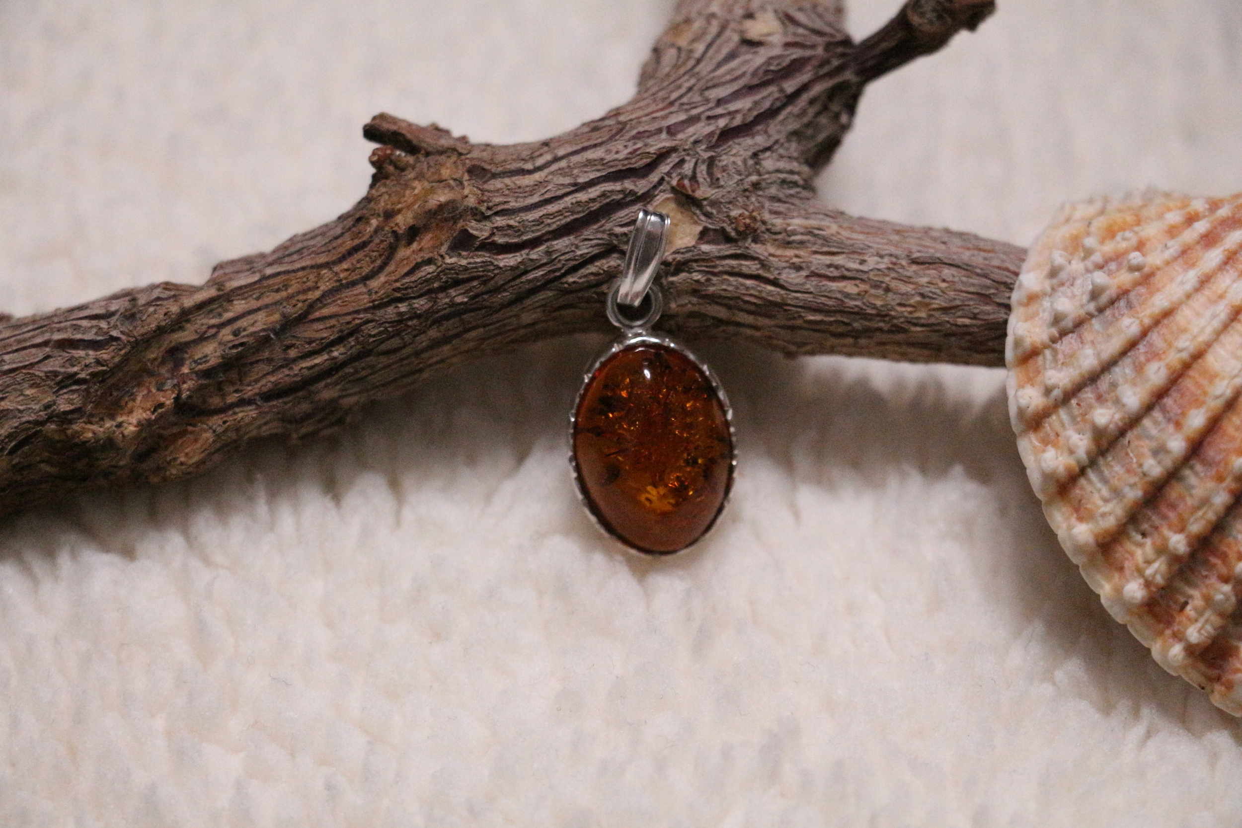 Pendentif de forme ovale en ambre cognac véritable et argent 925°/°°.
