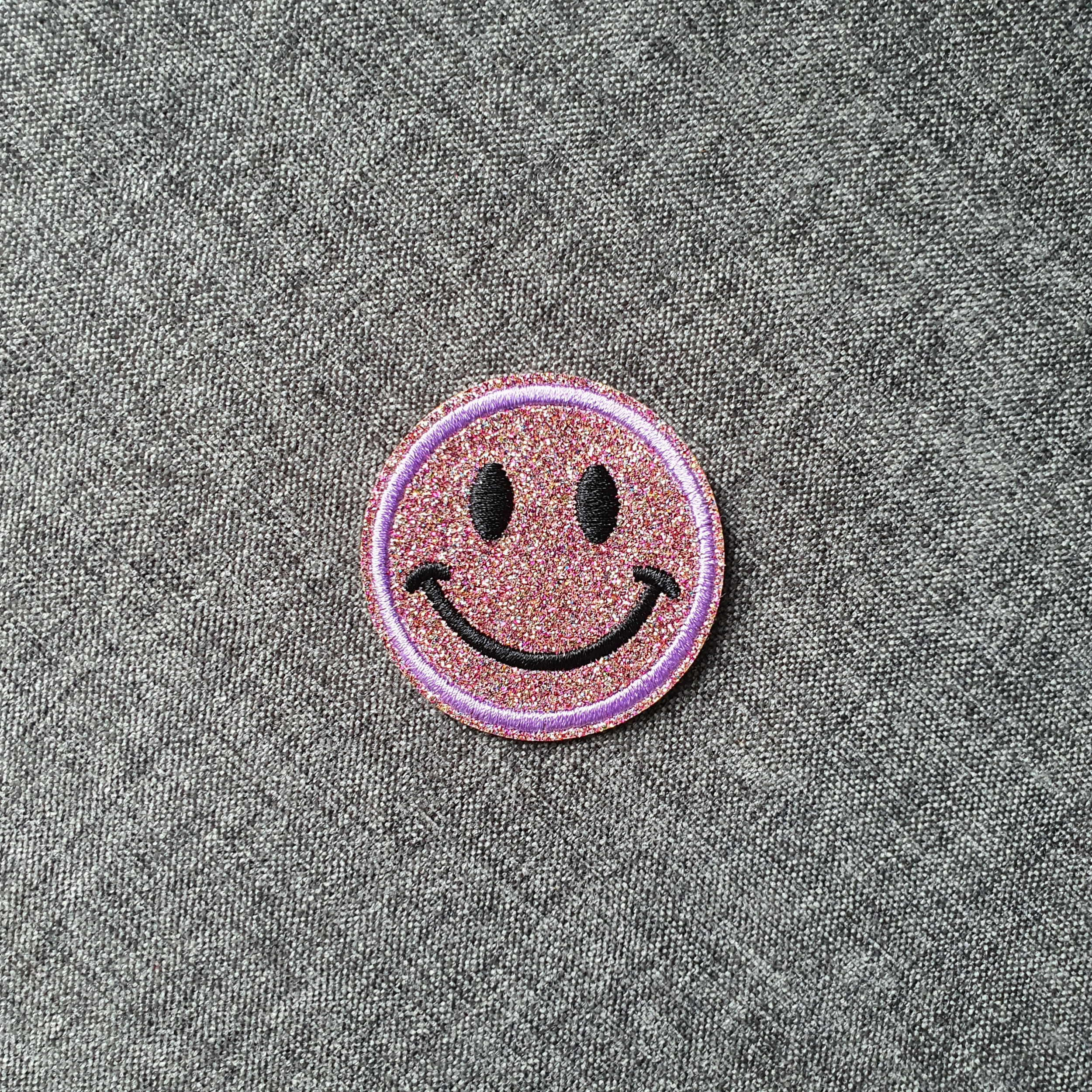 Patch thermocollant rond tête de smiley brillant mauve.