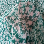 Tissu mousseline polyester fleuri blanc effet froissé sur fond vert. (1)