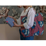 jeune femme avec un sac rose et bleu à l'épaule et manipulant une pochette en éponge