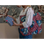 jeune femme avec un sac rose et bleu à l'épaule et manipulant une pochette en éponge