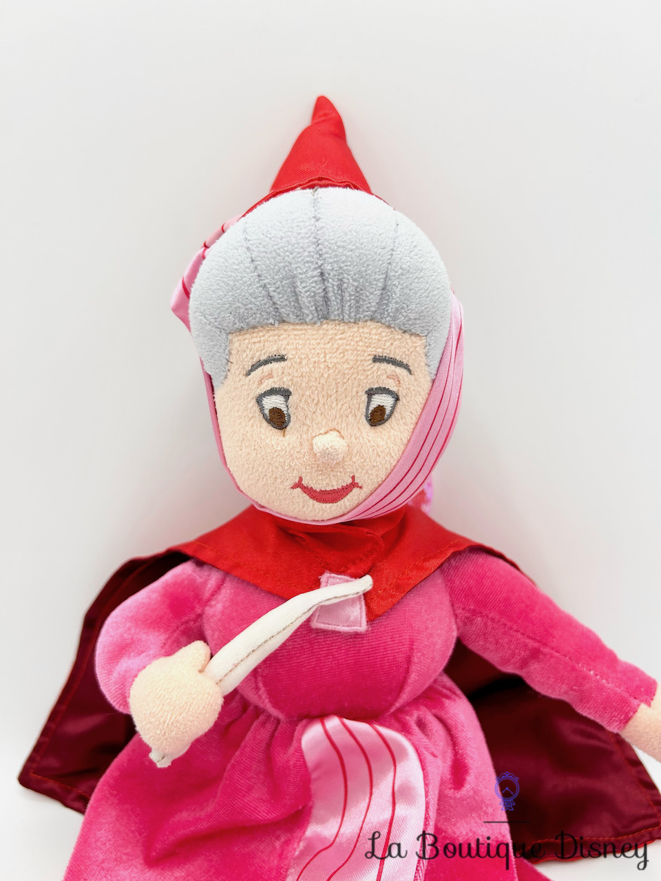 peluche-flora-fée-rouge-rose-la-belle-au-bois-dormant-disney-store-écusson-1