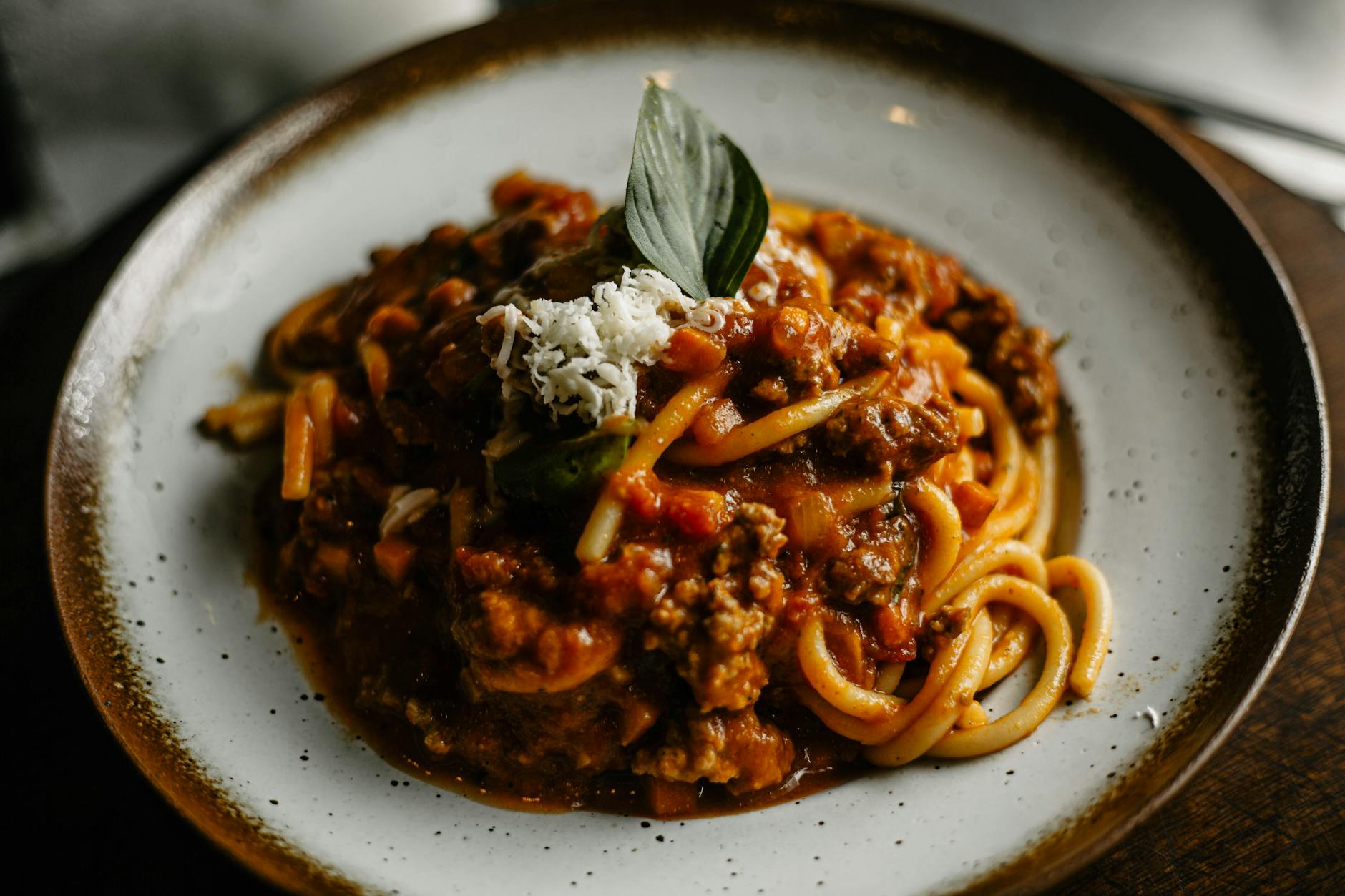 savoureuses pâtes italiennes avec une riche sauce à la viande garnie de basilic et de fromage