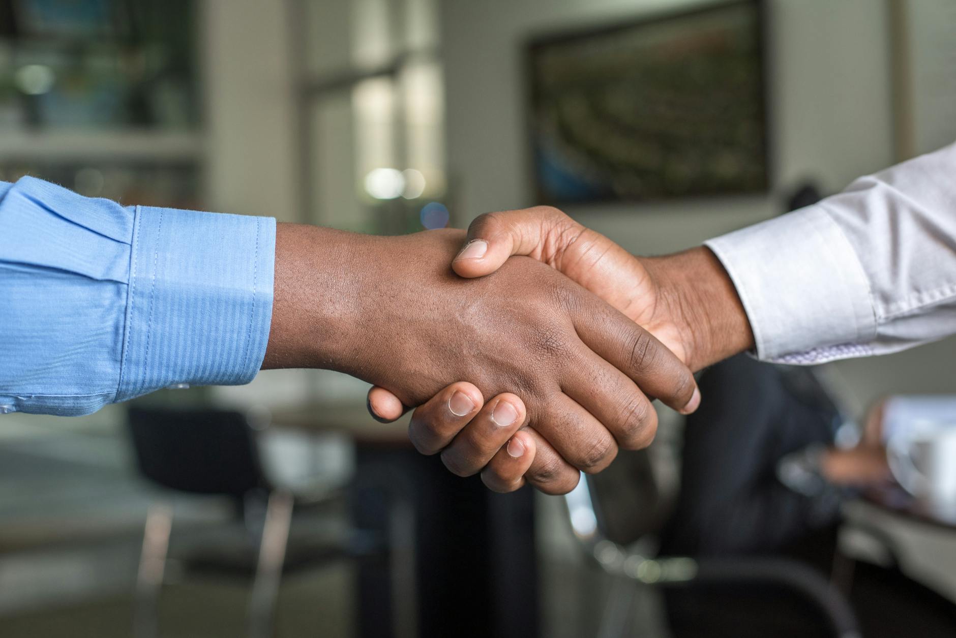 deux personnes en chemise a manches longues shakehand