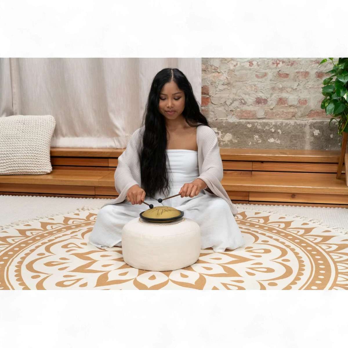 Jeune femme jouant du mini tongue drum doré Meinl assise en méditation