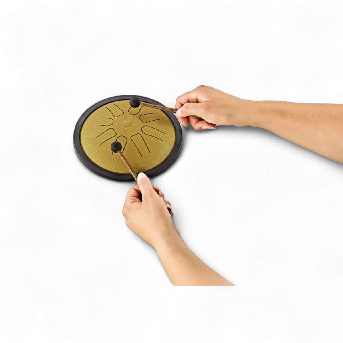 Gros plan sur les mains jouant du mini tongue drum doré avec deux maillets