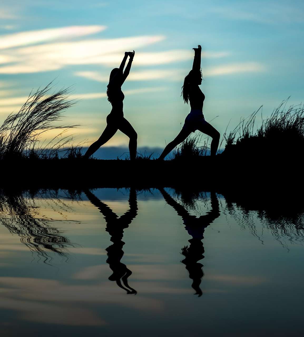 Femmes pratiquant le yoga au bord de l’eau – symbole d’équilibre et de bien-être articulaire grâce à une alimentation anti-inflammatoire
