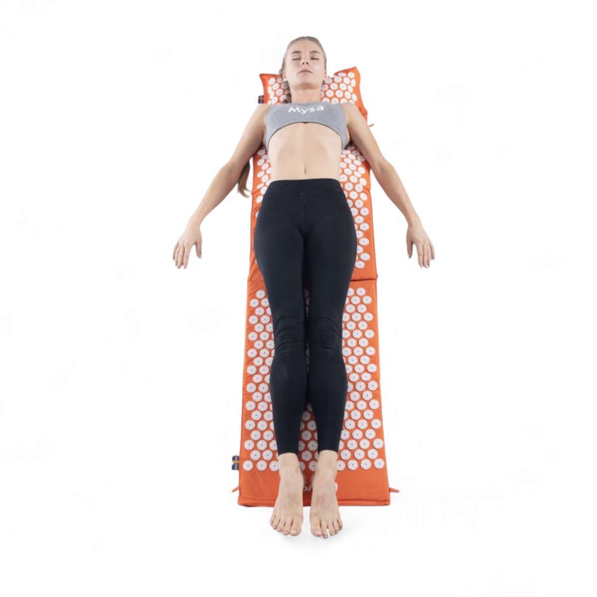 Femme allongée sur le ThermoMag Mysa Duo XXL de 180 cm, tapis d’acupression orange avec aimants