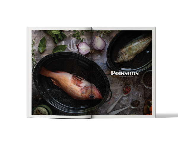 Livre de recettes Roaster ouvert sur une section poissons, avec poisson entier cuisiné dans une cocotte roaster Graniteware