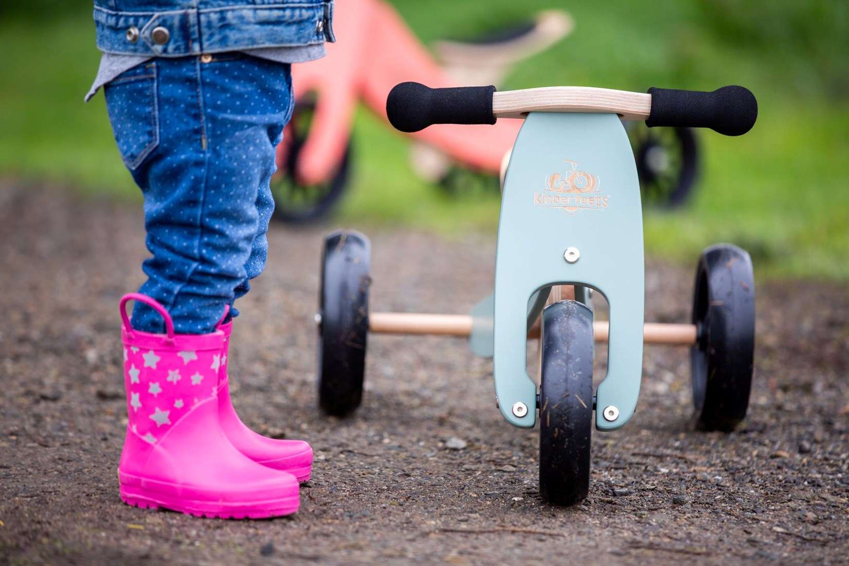 Enfant utilisant un tricycle Kinderfeets Tiny Tot en extérieur pour développer équilibre et motricité dès 12 mois