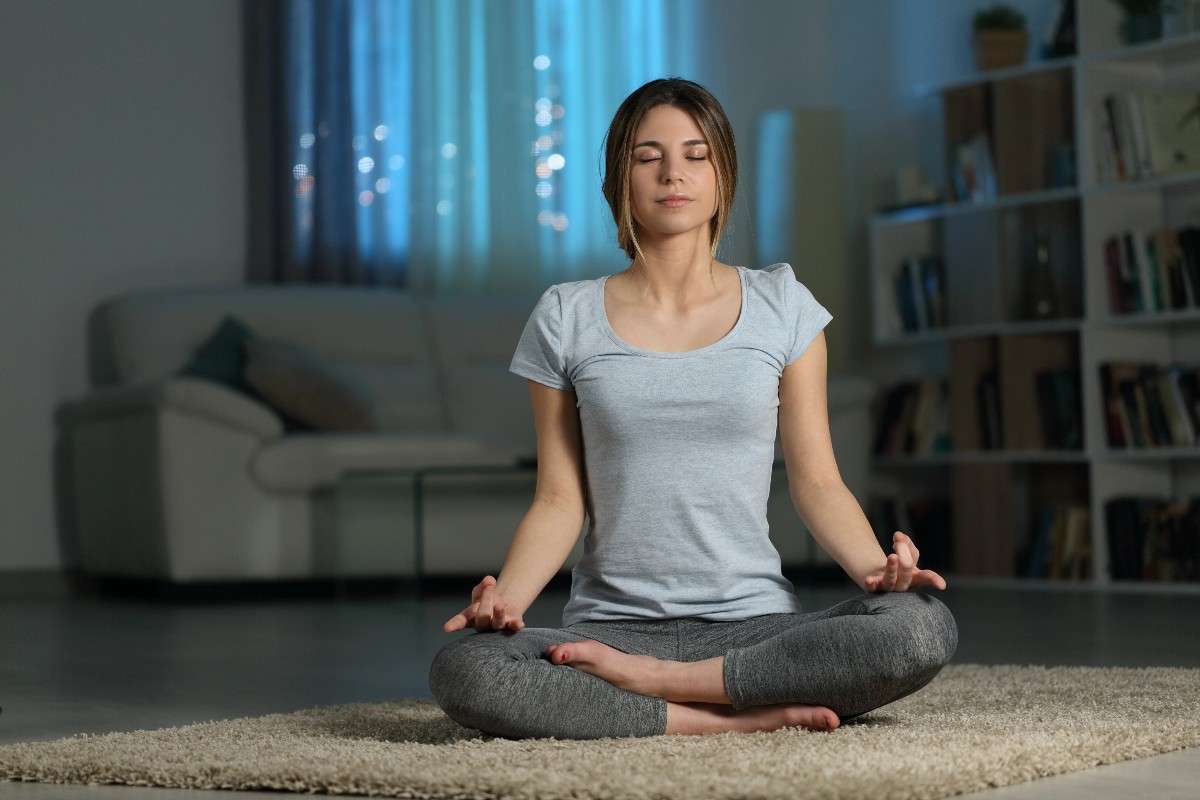 femme-en-meditation-assise-dans-un-salon-illustrant-une-seance-de-relaxation-a-la-maison-associant-respiration-et-acupression