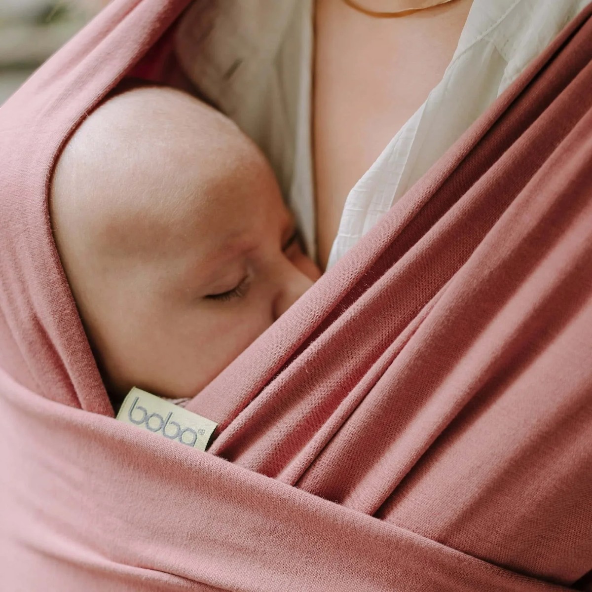 Boba Wrap Dusty Pink avec bébé endormi en portage physiologique