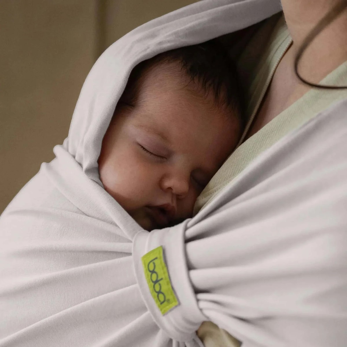 Nouveau-né endormi sous la capuche du porte-bébé Boba Bliss Stone