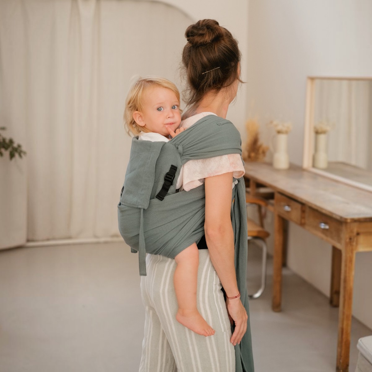Porte-bébé Ptit Evo Néobulle coloris Eucalyptus porté dans le dos, enfant qui se retourne