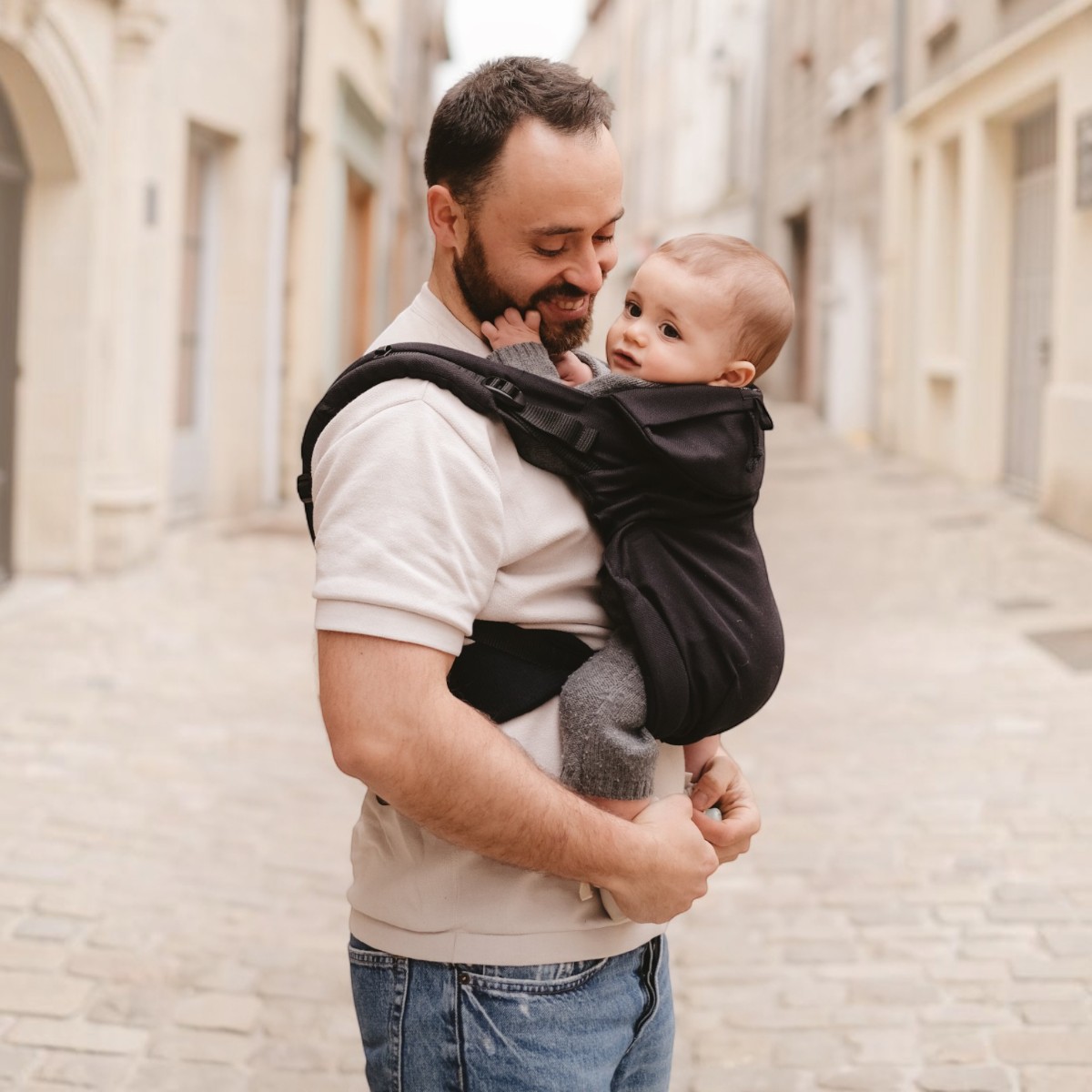 Néo Néobulle coloris Ébène, porté devant par le papa, bébé souriant