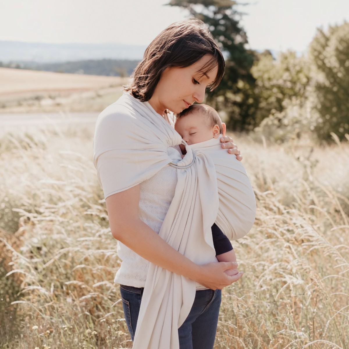 My Sling Néobulle écru en portage ventral avec un bébé endormi