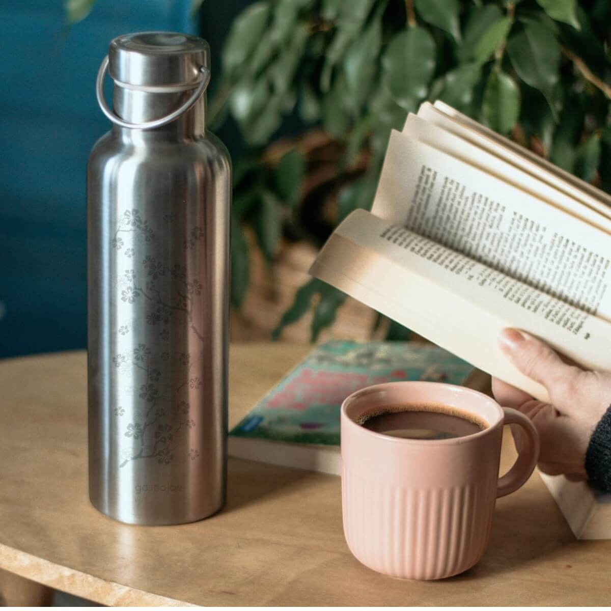Gourde isotherme Groovy cerisier à côté d’une tasse de thé