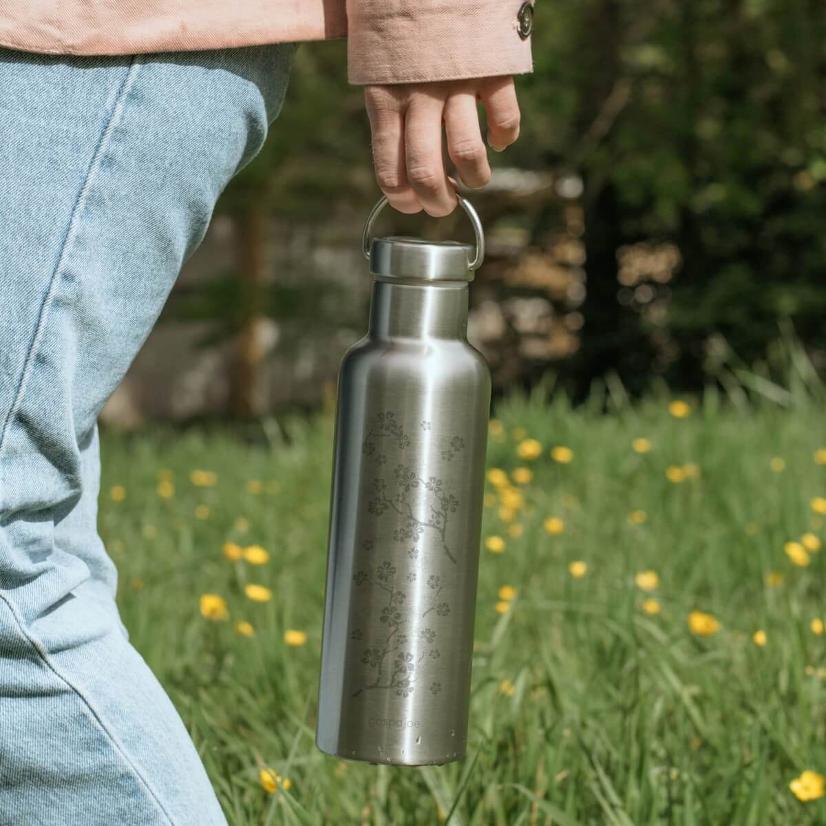 Gourde isotherme Groovy cerisier portée par son anse en balade