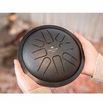 Jeu au maillet sur le mini steel tongue drum noir Meinl tenu à deux mains