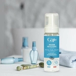 Flacon de mousse nettoyante visage bio Cap Hydra posé dans une salle de bain avec accessoires de beauté.