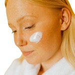 Application de la crème de jour au miel de Manuka sur la peau du visage