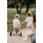 Enfant roulant sur le tricycle Tiny Tot Plus blanc Kinderfeets dans un chemin de parc
